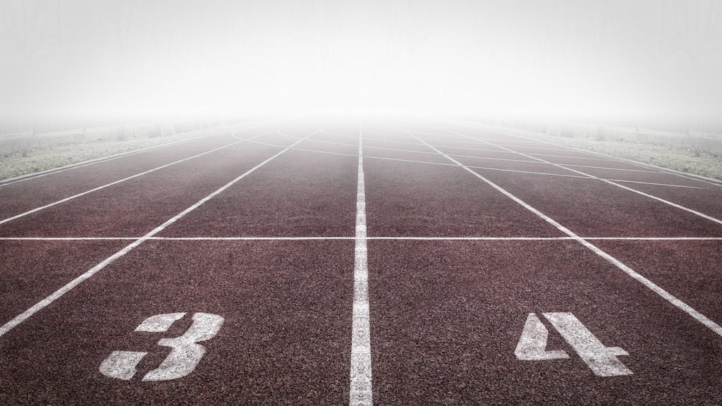 A foggy track field with visible lane numbers and white lines.